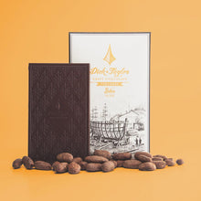 Load image into Gallery viewer, Unpackaged Belize bar in front of Belize bar packaging with cocoa beans and on a yellow background